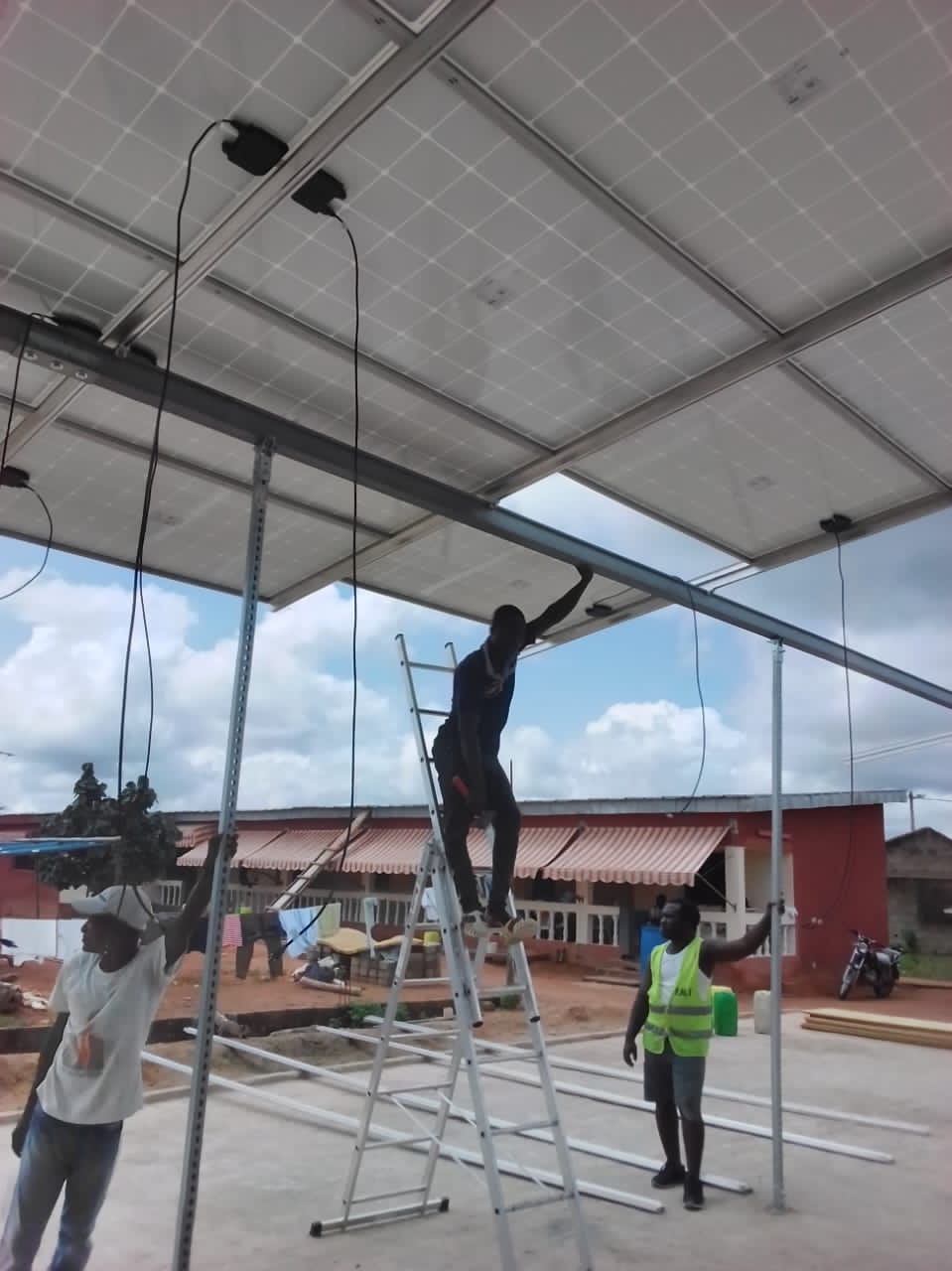 Équipe technique installant une structure de panneaux photovoltaïques
